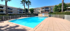 Relax by the rectangular pool surrounded by a tiled deck and lush greenery.