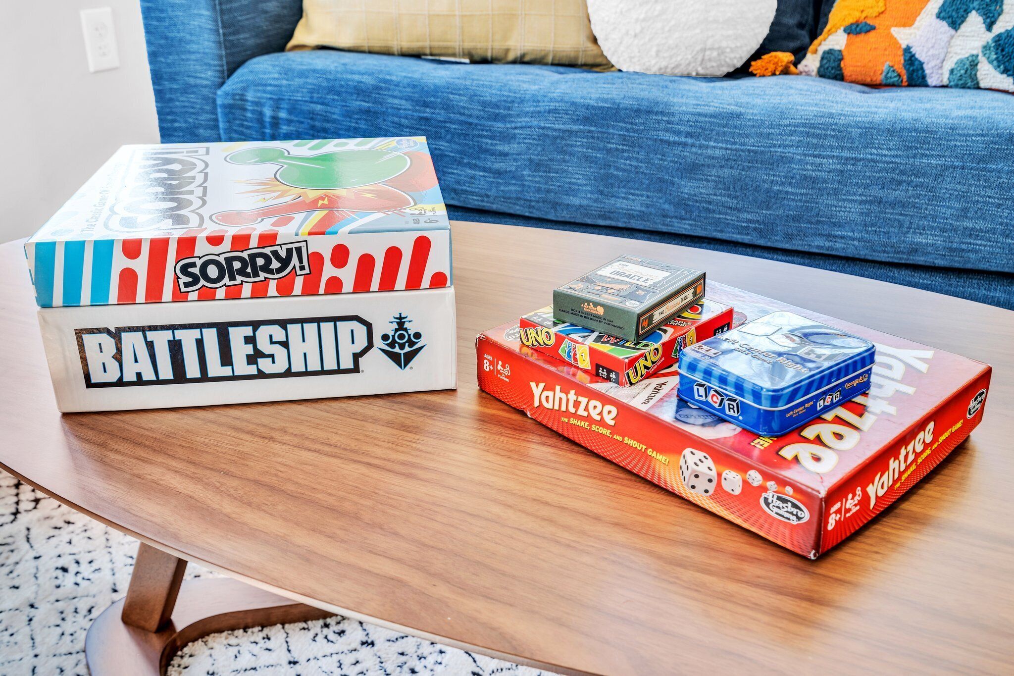 Una mesa de centro con una caja del juego Battleship y una caja del juego Yahtzee.