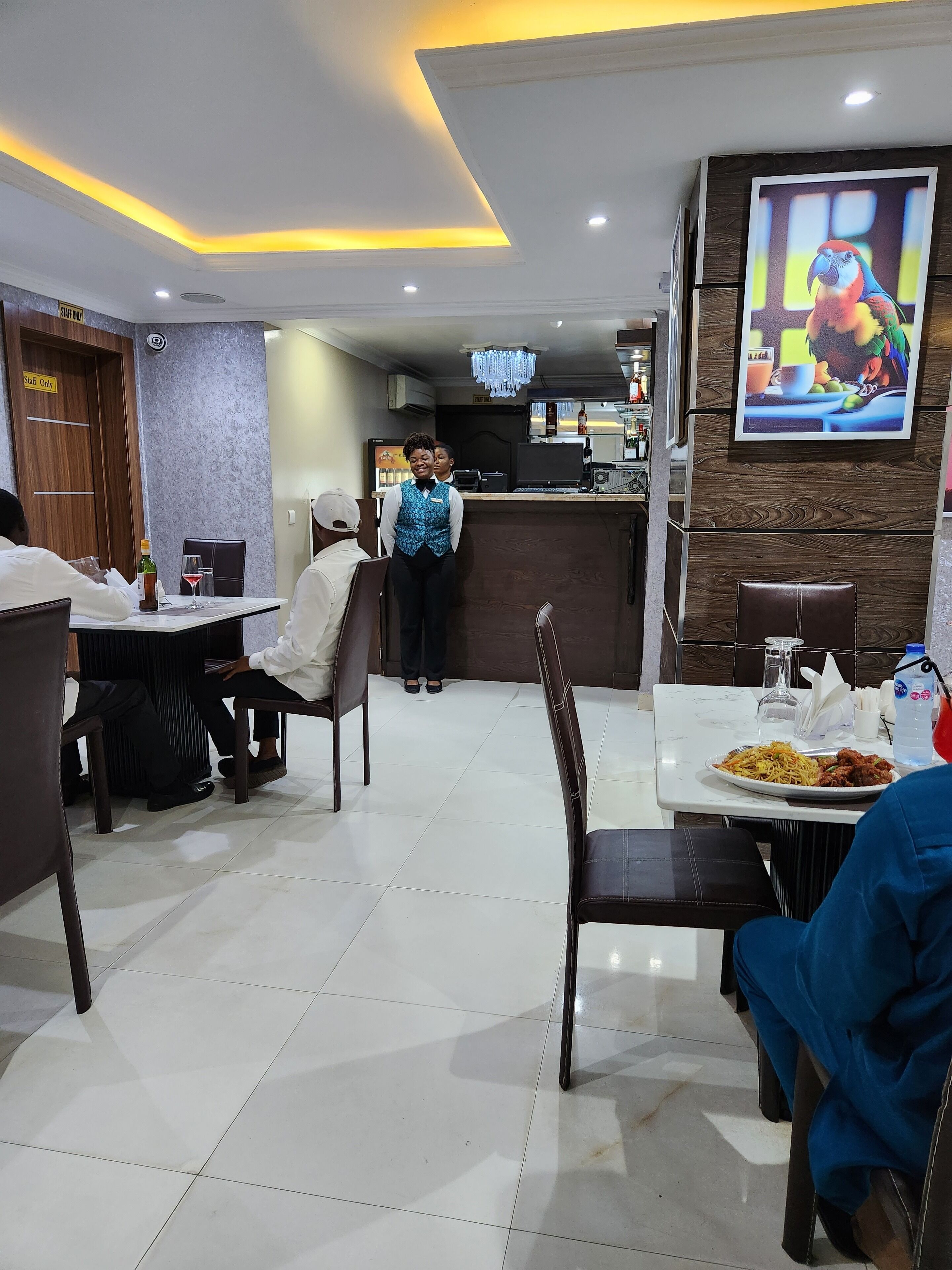 A restaurant with a clean, modern interior, featuring a tiled floor and a mix of wooden and metal furniture.