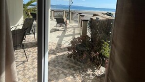 A balcony with a tiled floor, outdoor furniture, and a view of the beach. - Hotel y Restaurante Mama Ines (Hicaco)