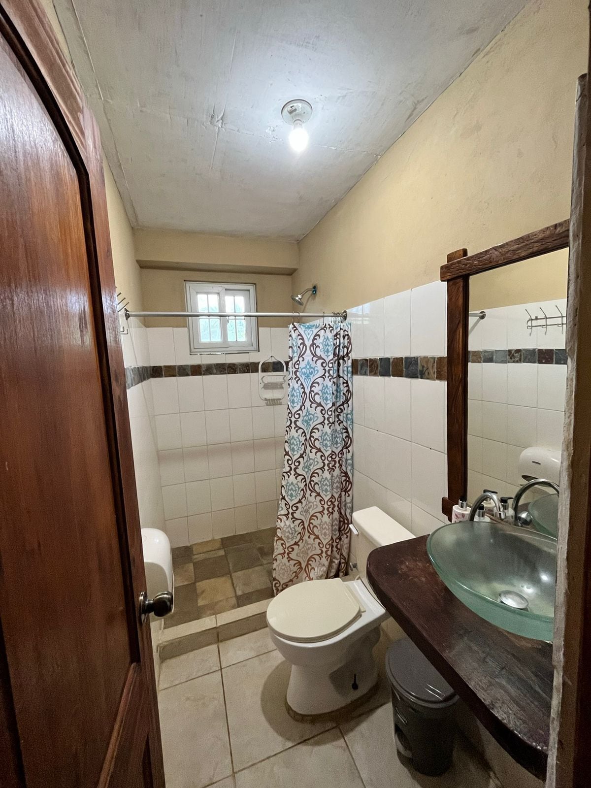 Une salle de bain comprenant des toilettes, un lavabo et un espace douche.