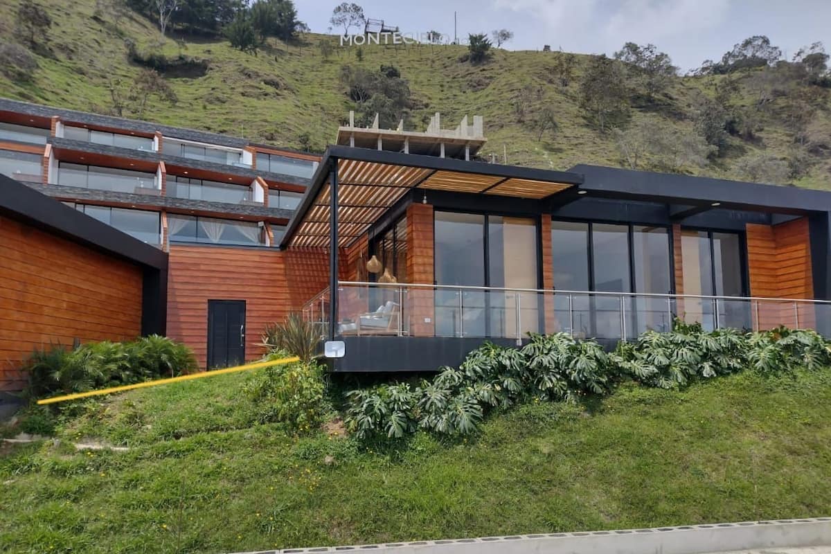 Un bâtiment moderne doté d’une façade en bois, de grandes fenêtres et d’un espace extérieur couvert.