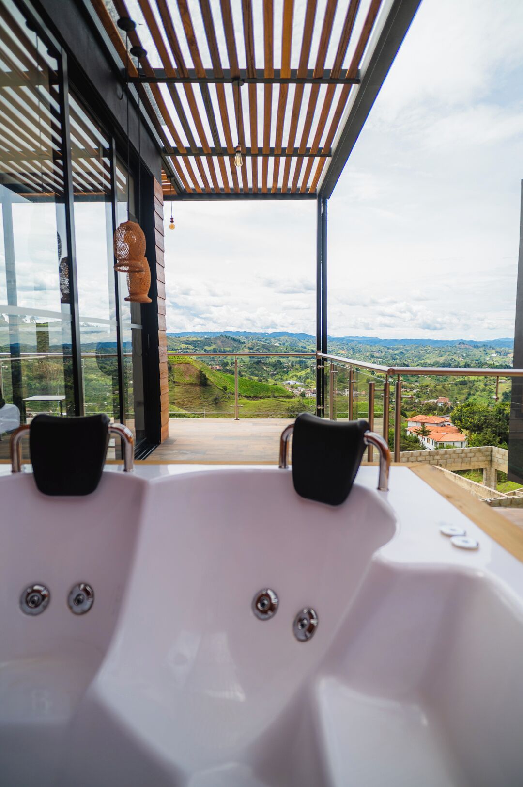A modern outdoor hot tub with a view of a green landscape.