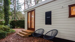 Una cabaña pequeña con una puerta de madera, un letrero negro con la palabra 