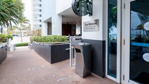 A Starbucks sign, a sign for The Westin, and a modern building facade.