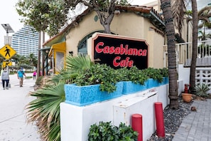 A building with a sign that reads 'Casablanca Cafe' and a pedestrian crossing sign.