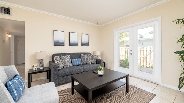 A living room with a sofa, coffee table, and a view through a glass door.