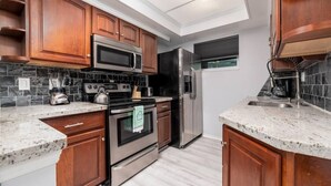 A kitchen with wooden cabinets, stainless steel appliances, and a tiled backsplash. - Short Walk to Wilton Drive! Apt4 (Wilton Manors)