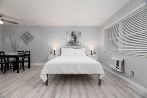 Une chambre à coucher avec un lit, des tables de chevet, un bureau et une chaise.
