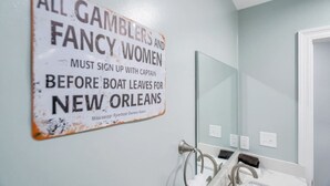 A bathroom with a sign on the wall stating 'All Gamblers and Fancy Women Must Sign Up with Captain Before Boat Leaves for New Orleans'. - Conveniently Located Contemporary 6 Bed/6 Bath 15 Min to Downtown (Metairie)
