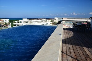 Relax by the ocean with a view from our rooftop pool, surrounded by comfortable seating and dining areas.
