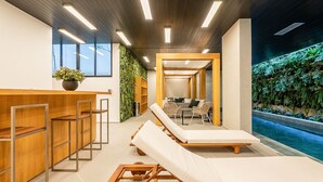 Een wellnessruimte met houten meubels, een receptiebalie en uitzicht op een zwembad.