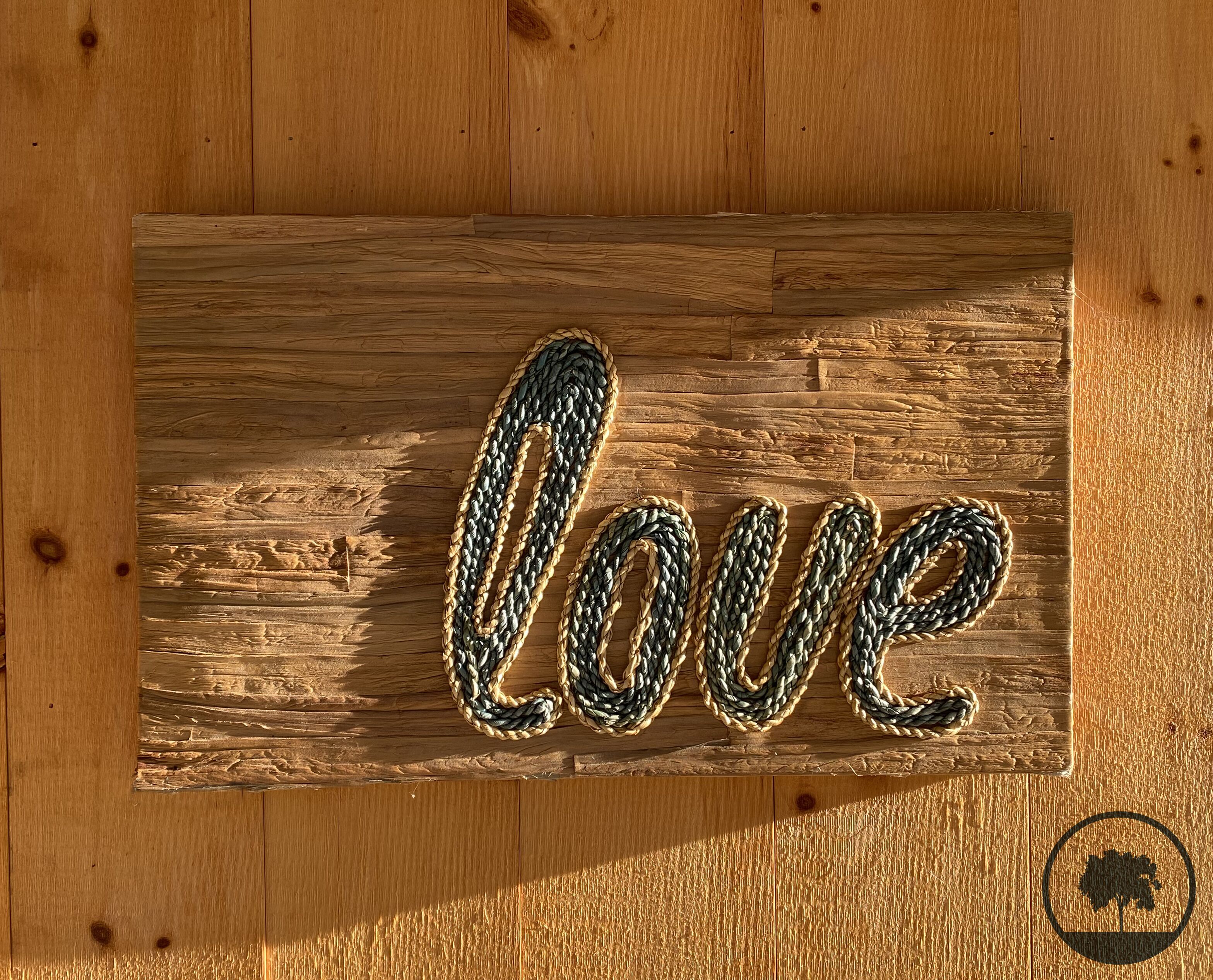 Une enseigne en bois sur laquelle est inscrit le mot « amour » dans une police de caractères décorative.