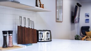 A kitchen counter with a toaster, salt and pepper shakers, and a knife block. - Separate Reality By Revelstoke Vacations (Revelstoke)