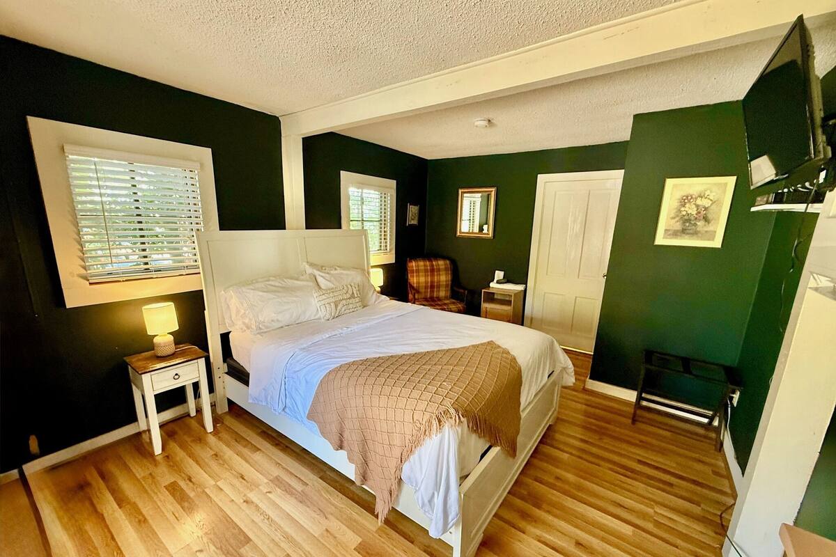 A bedroom with a bed, bedside tables, a wardrobe, and a mirror.