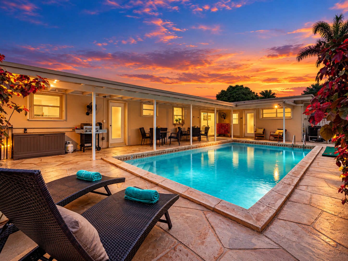 A swimming pool with lounge chairs and a covered patio area.