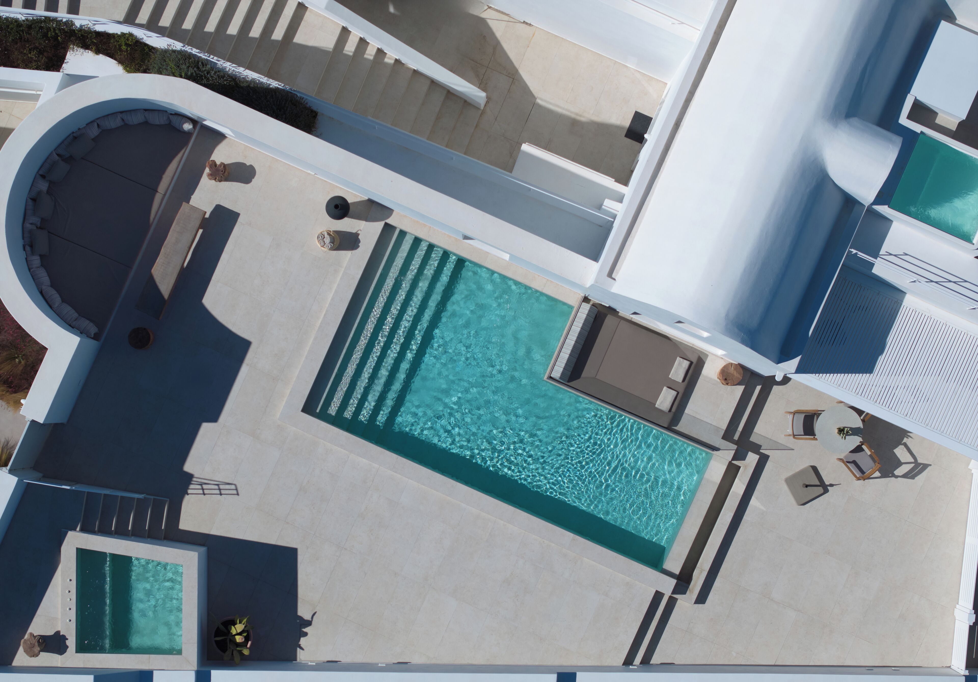 Ein Luftbild eines Dachpoolbereichs mit Whirlpool, Sitzgelegenheiten und einem kleinen Pool.