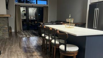 A modern kitchen with a central island, dark cabinetry, and pendant lighting.