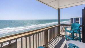 A balcony with a view of the ocean, two turquoise chairs, and a small table. - Shore Beats Work - Oceanfront New Balcony 3rd Flr (North Topsail Beach)