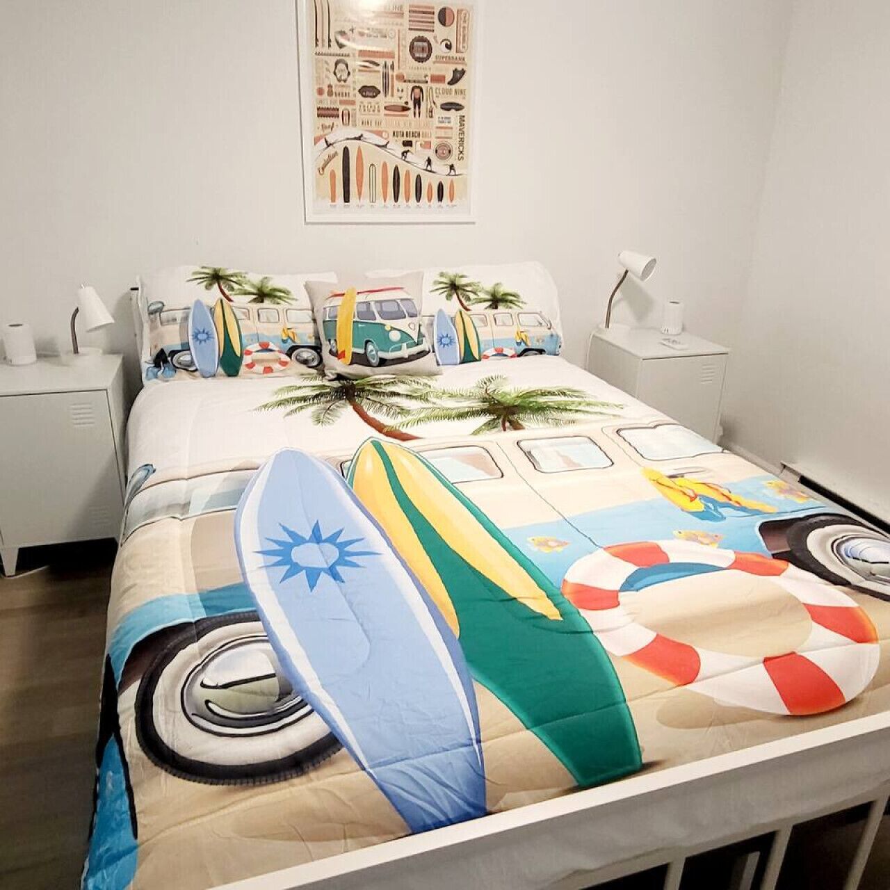 A bed with a surfboard and palm tree design, a nightstand, and a wall art piece.