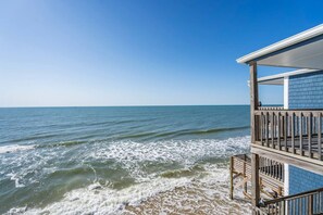 Ein Strandgrundstück mit einer Holzterrasse und Blick auf den Ozean.