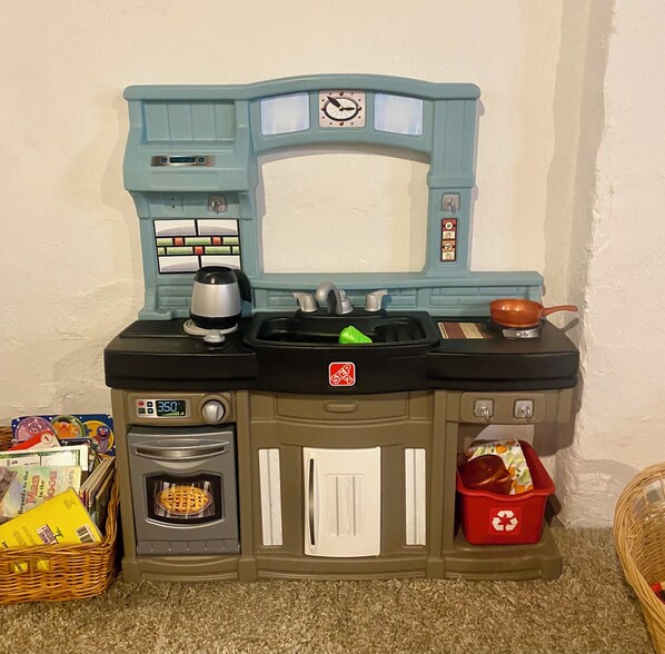 Una cocina de juguete con microondas, horno y fregadero.