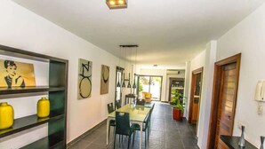 A hallway with a dining area, a staircase, and a door leading to another room. - Villa Lanson - Poolside Retreat by Villas Now (Playa Blanca)