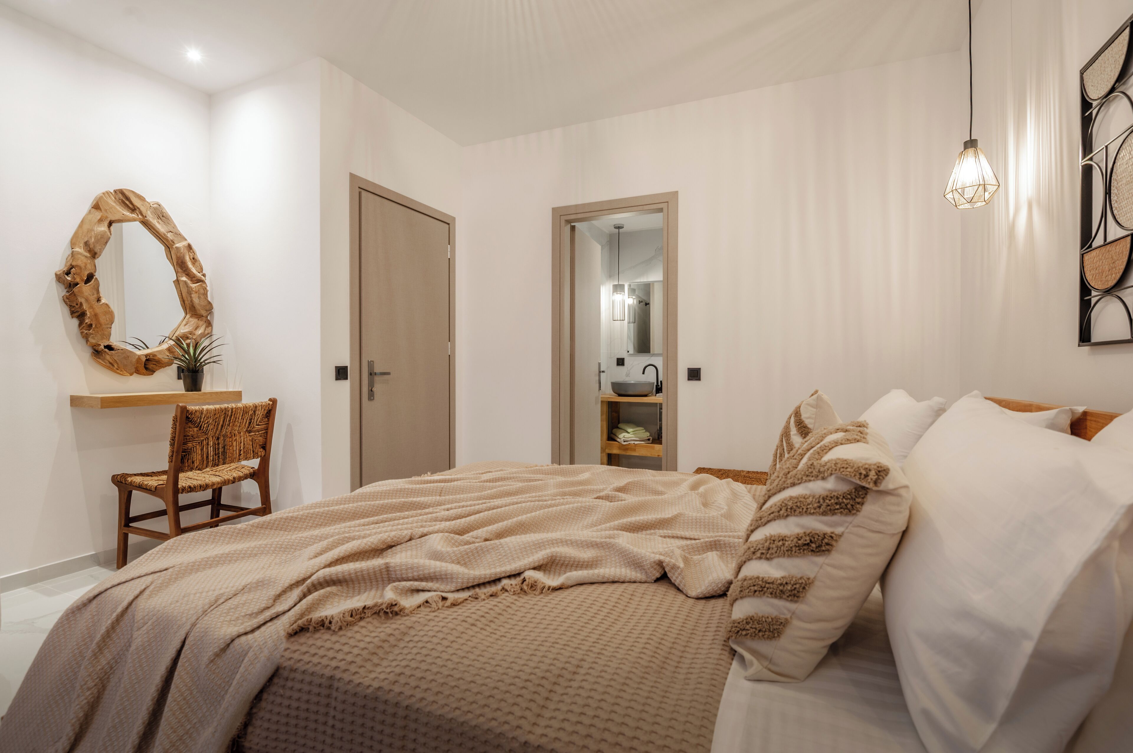 Une chambre à coucher avec un lit, une chaise, un miroir et une étagère sur laquelle se trouve un bol.