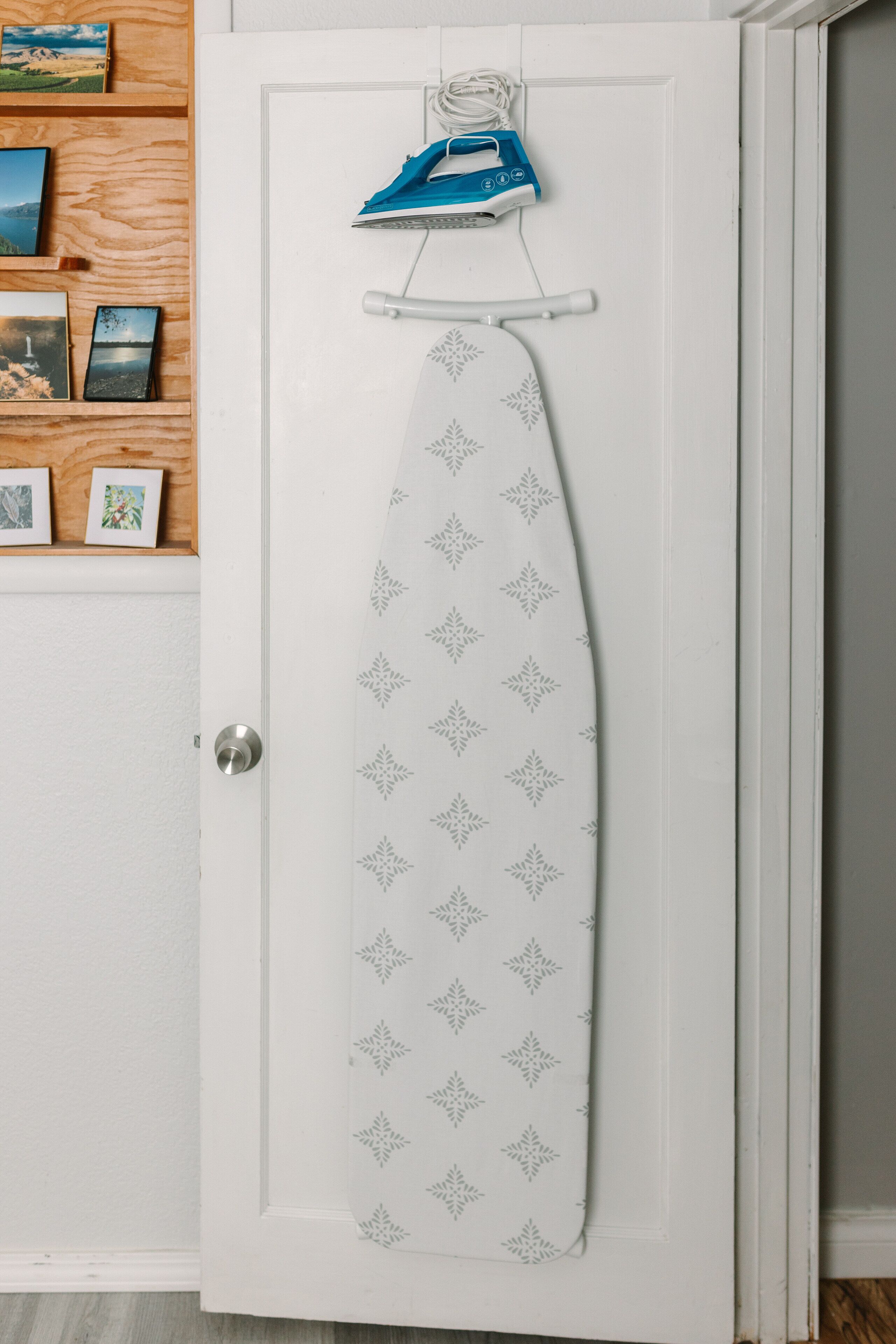 Une porte blanche ornée d’un fer à repasser suspendu et d’une cravate à motifs.