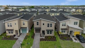 A residential area with multiple two-story houses, each with a garage, driveway, and small front yard.