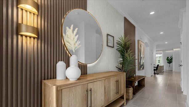 A modern reception area with a wooden console, a large mirror, and wall-mounted lighting.