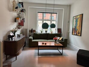 Ein modernes Wohnzimmer mit einer Couch, einem Couchtisch und Pendelleuchten.