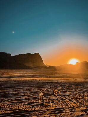 Experience the breathtaking desert landscape with a majestic rock formation at its center.