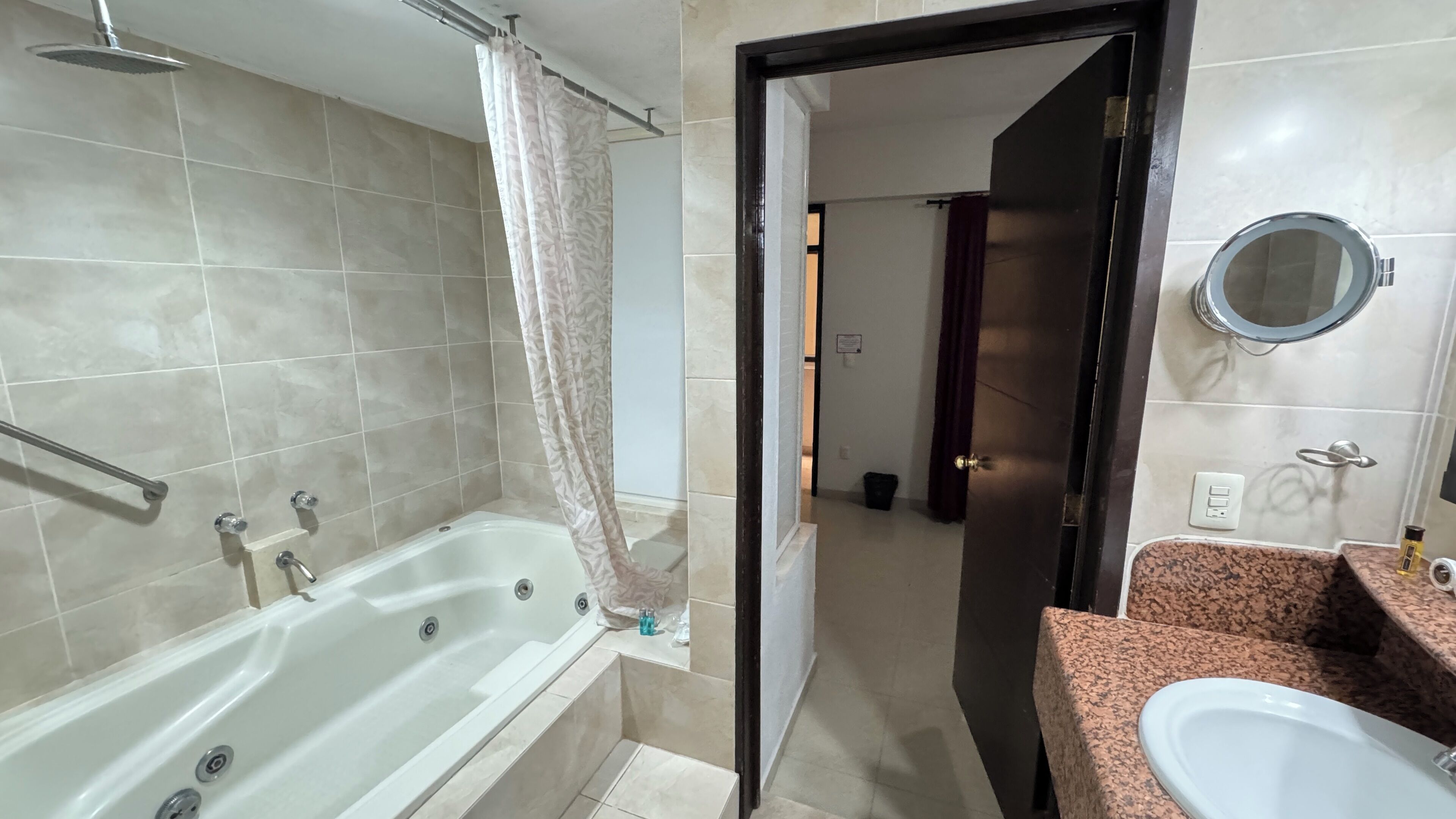 Een badkamer met een bad, douche en een wastafel met spiegel.