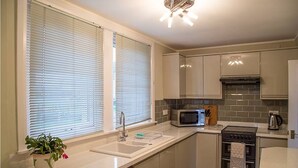 Una cocina moderna con lavavajillas, microondas, horno y un lavabo.