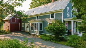 A two-story house with a front porch, a garage, and a covered driveway. - Charming Chester Farmhouse near Near VT Slopes (Chester)