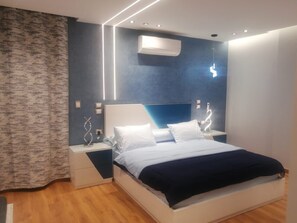 Relax in this serene bedroom with a large bed, two bedside tables, and a patterned curtain.
