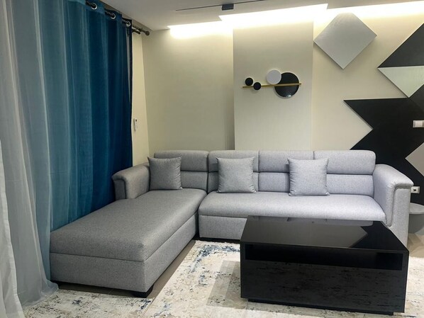 Relax in this stylish living room with a comfortable sofa and geometric wall art.