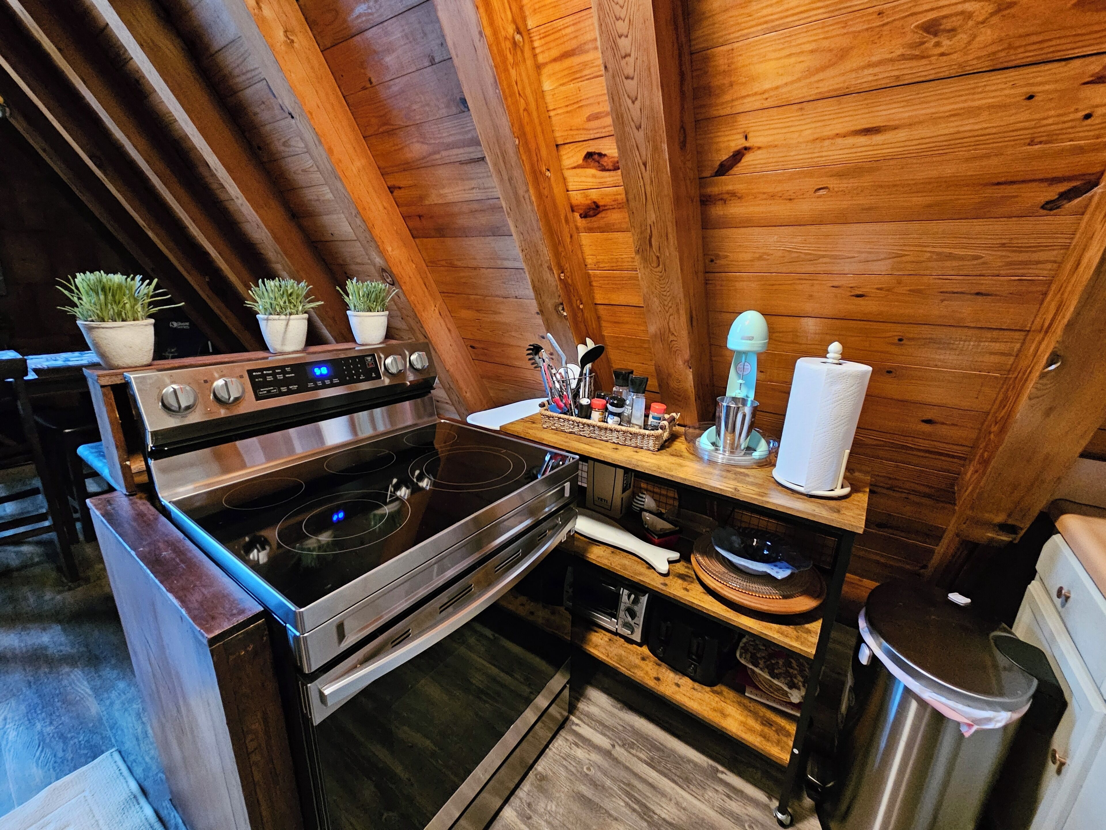 A compact kitchen with a stainless steel stove, wooden cabinets, and a small countertop.