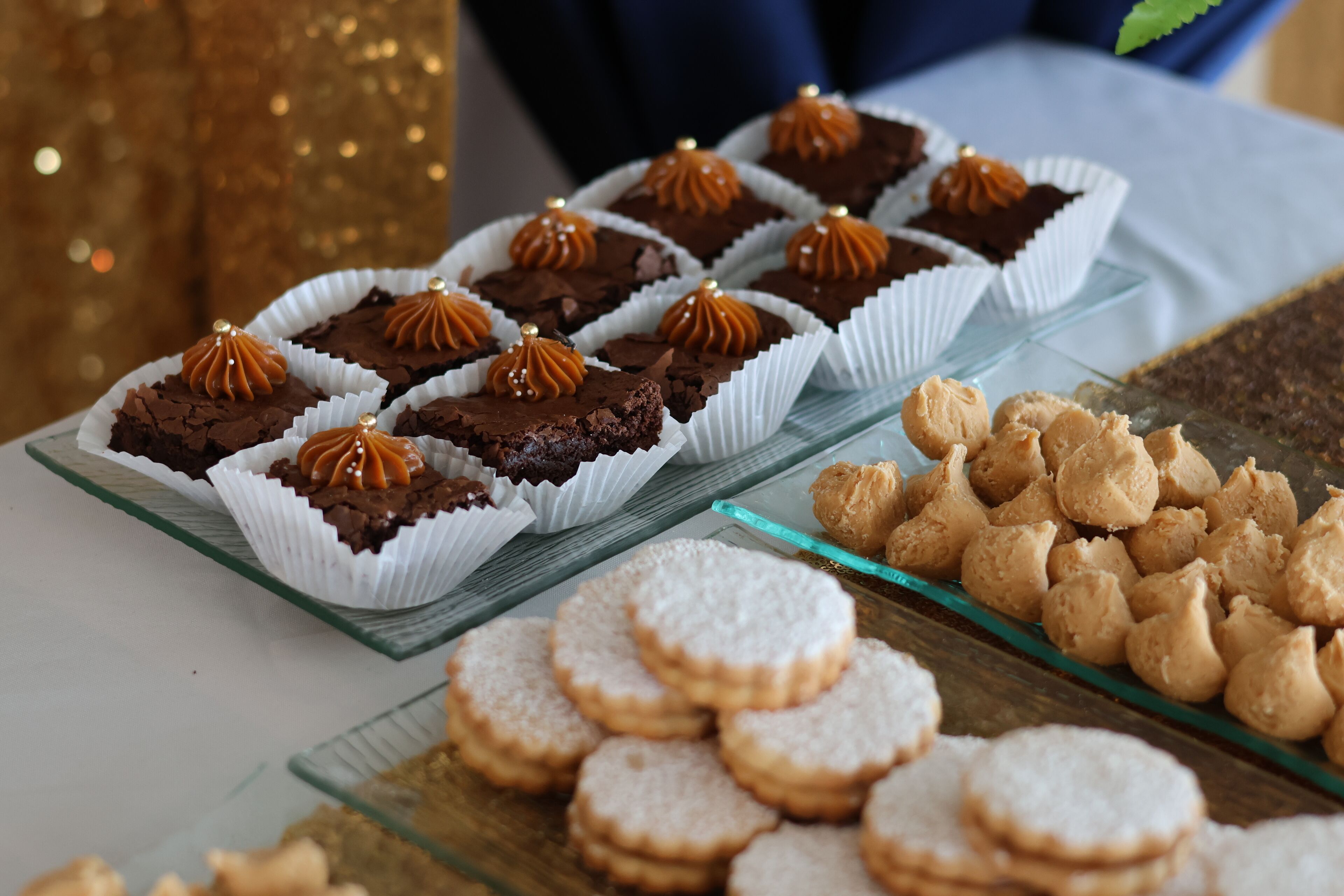 Una mesa de postres con diversos pasteles y galletas.