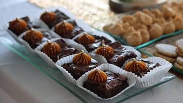 Een glazen serveerplank met chocoladedesserts en koekjes.
