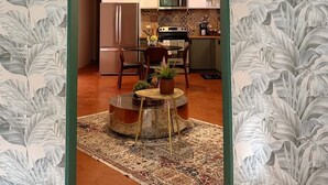 A modern kitchen with a central island, a ceiling fan, and a dining area with chairs and a table. - Don Charlie Building (San Juan)