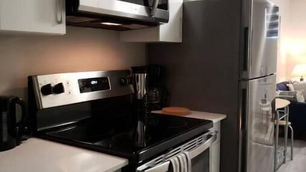 A modern kitchen with a microwave, stove, oven, and refrigerator.