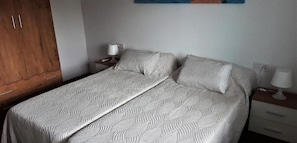 Cozy retreat with a single bed, wooden wardrobe, and bedside table.