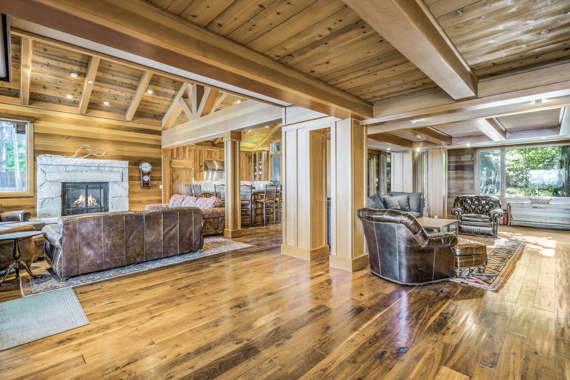 Un salón espacioso con chimenea, muebles de cuero y vigas de madera.