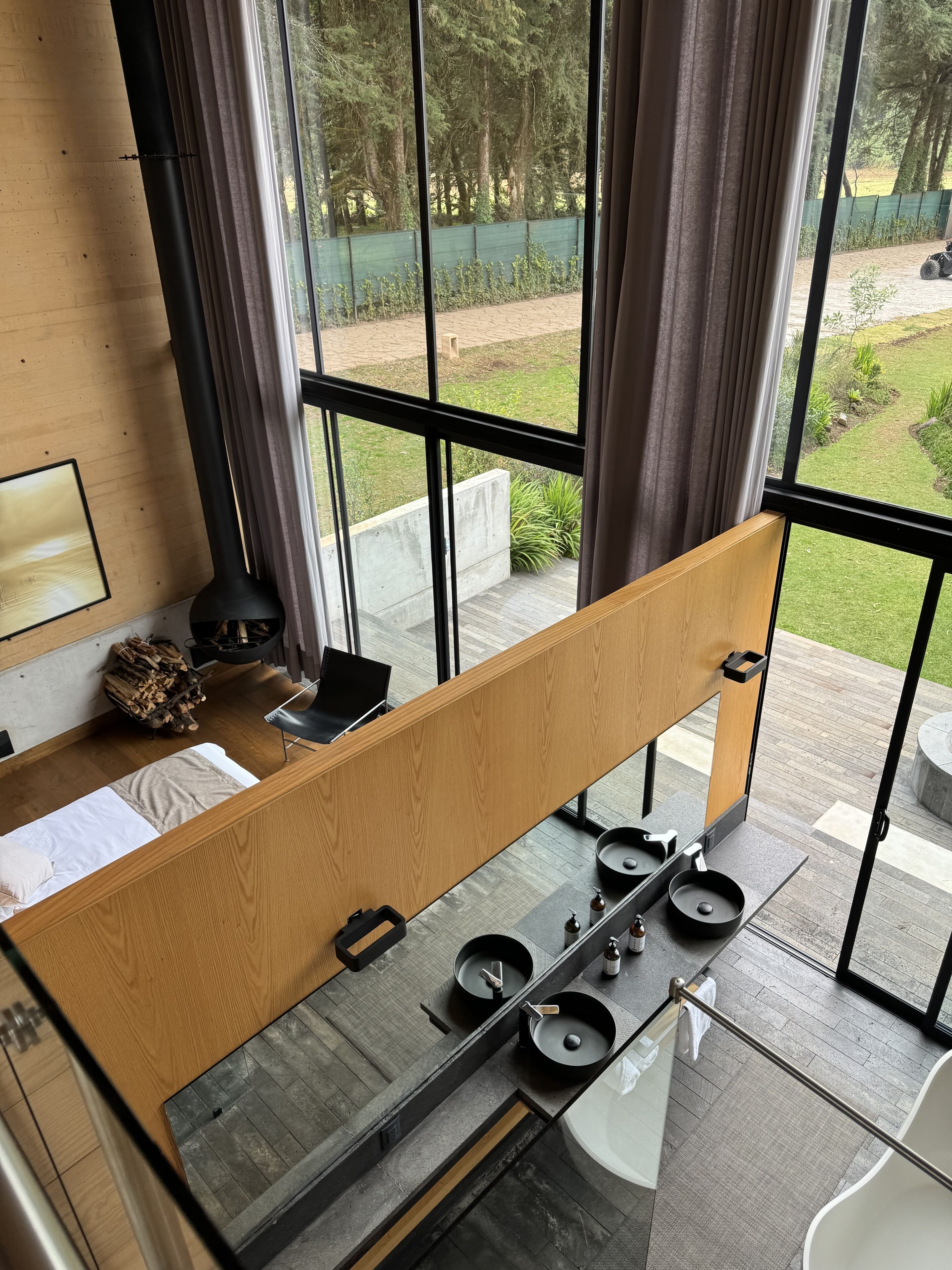 A modern kitchen with a large window, a wooden bench, and a dining area.