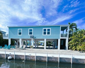 A two-story house with a balcony, a covered porch, and a pool area. - Premium Blue Coral Lagoon Waterfront (Big Pine Key)