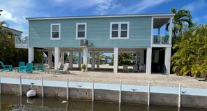 A two-story house with a covered porch, outdoor seating, and a pool. - Premium Blue Coral Lagoon Waterfront (Big Pine Key)