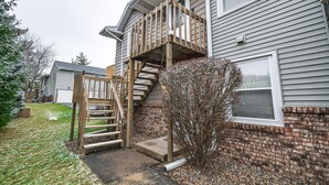 A two-story house with a wooden staircase leading to a balcony. - Welcoming Condo in Davenport: Central Location! (Davenport)