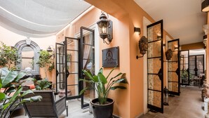 A hotel lobby with a large potted plant, a seating area, and a sign reading "ARTESANA." - Artesana – Privately Owned Rosewood Residence (San Miguel de Allende)